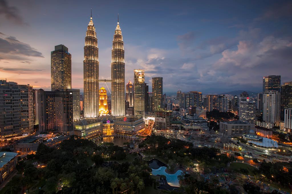 Stunning Kuala Lumpur skyline featuring the illuminated Petronas Towers at twilight.