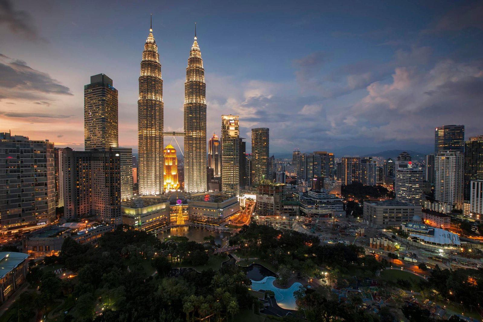 Stunning Kuala Lumpur skyline featuring the illuminated Petronas Towers at twilight.